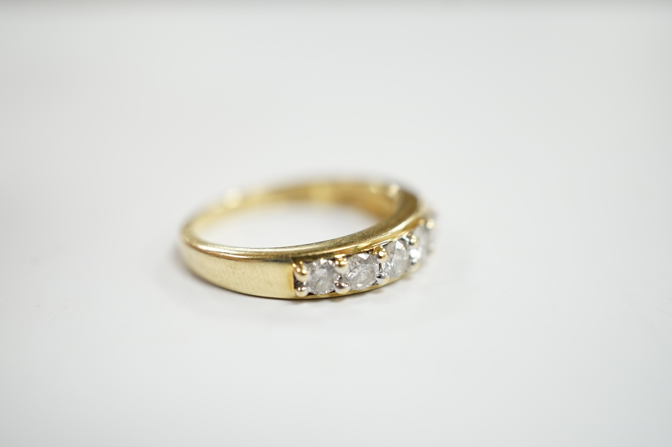 A modern 18ct gold and seven stone diamond set half hoop ring, size N, gross weight 4 grams.
